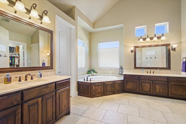 bathroom with vanity, a tub to relax in, high vaulted ceiling, and tile patterned floors