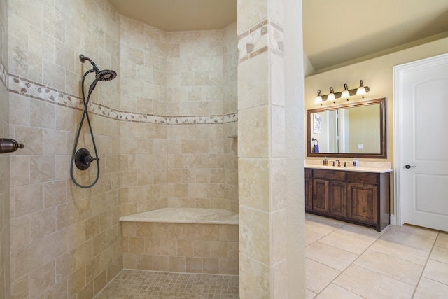 bathroom with vanity, a tile shower, and tile patterned flooring