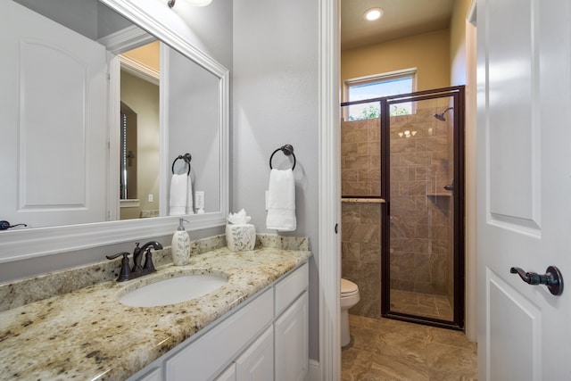 bathroom with toilet, an enclosed shower, and vanity