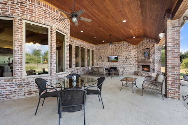 view of patio / terrace with an outdoor fireplace and ceiling fan