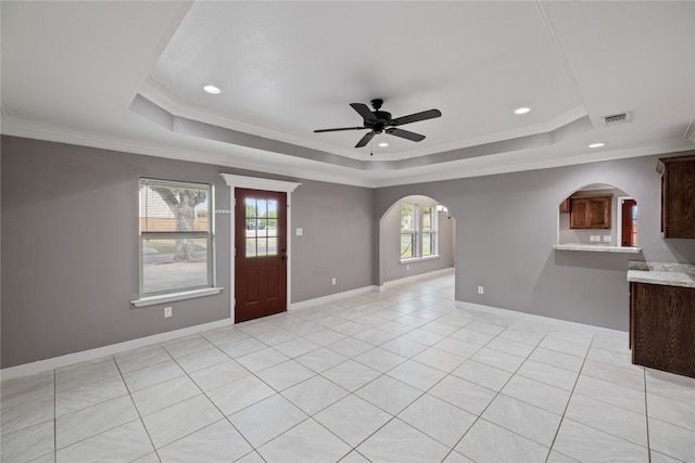 empty room with crown molding, ceiling fan, and a tray ceiling