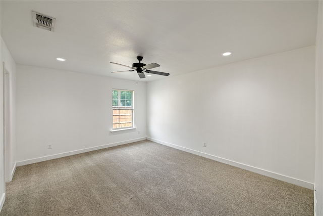 spare room with light colored carpet and ceiling fan