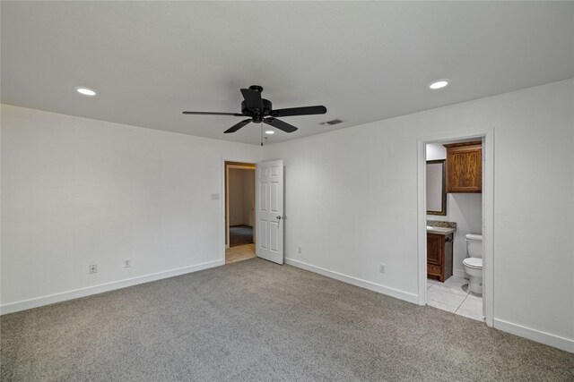 unfurnished bedroom featuring ensuite bath, light carpet, and ceiling fan