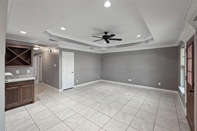 interior space featuring a tray ceiling, ceiling fan, and crown molding