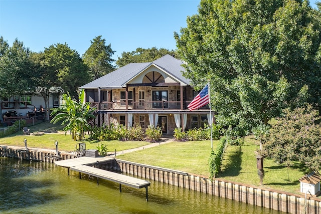 rear view of house with a lawn, a water view, and a balcony