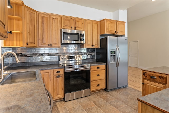 kitchen with decorative backsplash, appliances with stainless steel finishes, and sink