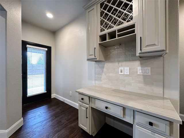 mudroom with dark wood-type flooring and built in desk