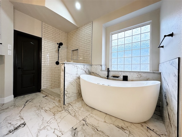 bathroom with lofted ceiling, tile walls, and separate shower and tub