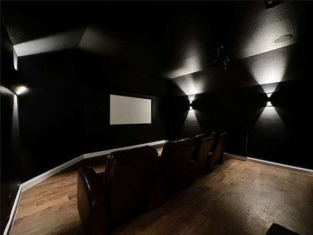 home theater with hardwood / wood-style flooring and vaulted ceiling