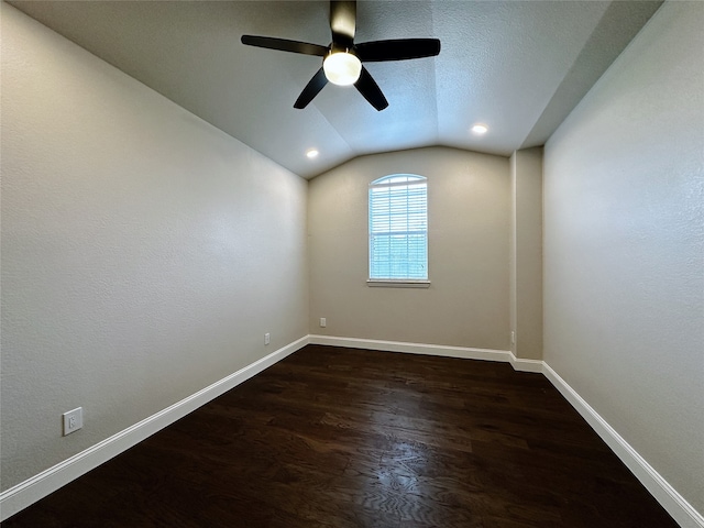 empty room featuring ceiling fan, dark hardwood / wood-style floors, a textured ceiling, and vaulted ceiling