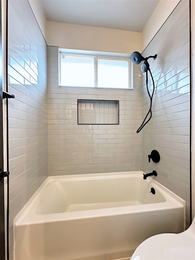 bathroom with tiled shower / bath combo, toilet, and plenty of natural light