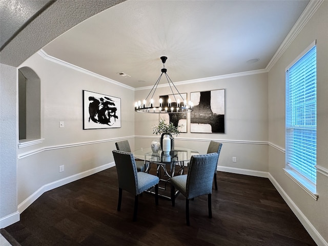 dining space with crown molding, dark wood-type flooring, and an inviting chandelier