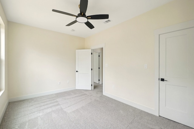 interior space with ceiling fan and light colored carpet