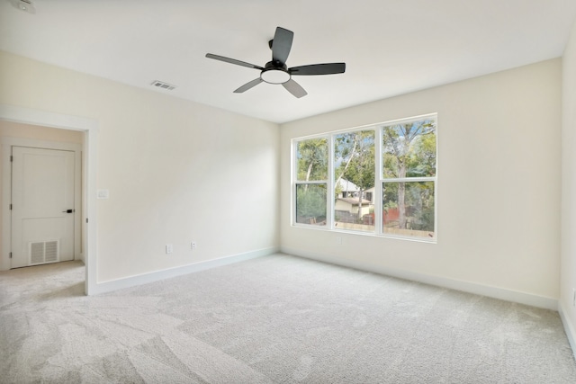 spare room with ceiling fan and light colored carpet