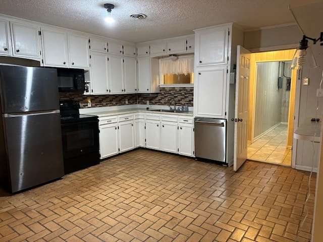 kitchen featuring visible vents, black appliances, light countertops, white cabinetry, and backsplash