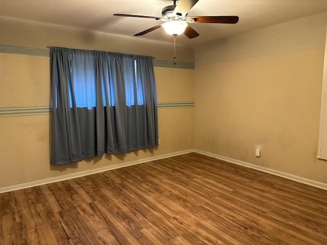 empty room with ceiling fan, baseboards, and wood finished floors