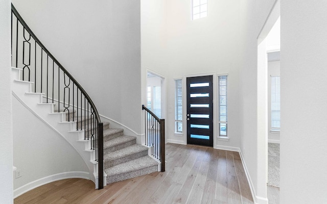 foyer entrance featuring wood-type flooring and a high ceiling