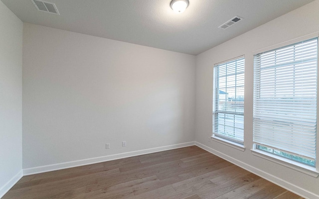 unfurnished room with hardwood / wood-style flooring