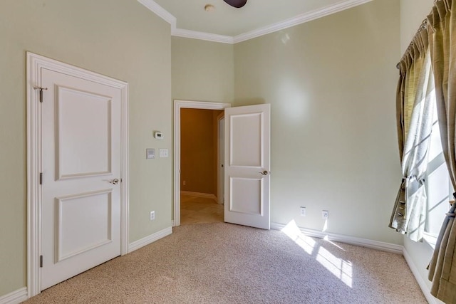 carpeted spare room with ornamental molding and ceiling fan