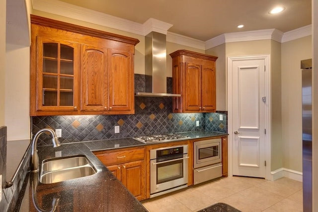 kitchen featuring wall chimney exhaust hood, appliances with stainless steel finishes, backsplash, and sink