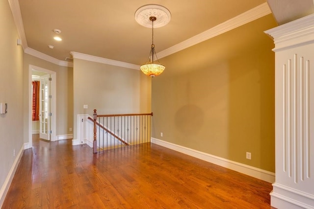 spare room with ornamental molding and dark wood-type flooring