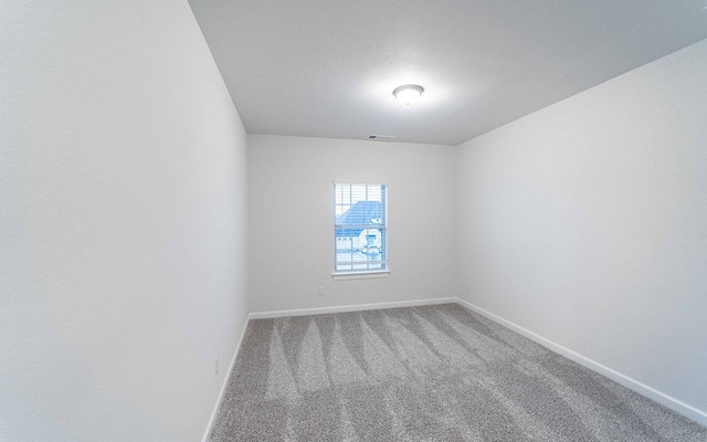 carpeted empty room with a textured ceiling