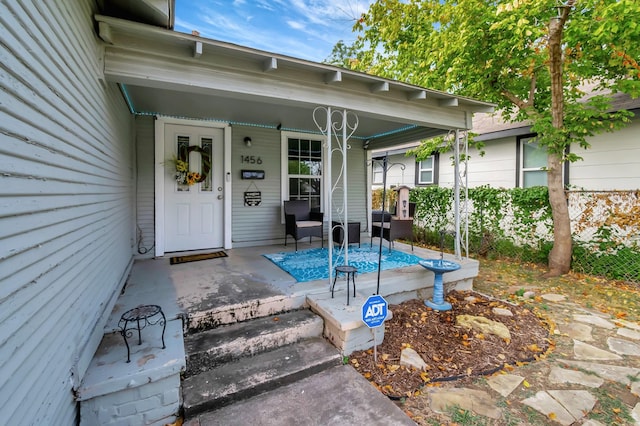 view of exterior entry featuring covered porch