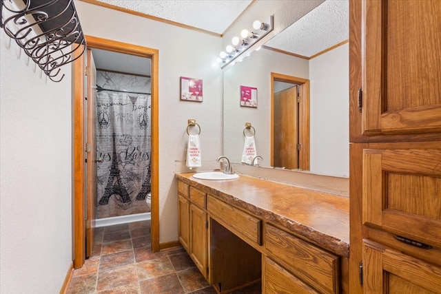 bathroom with a textured ceiling, vanity, ornamental molding, and walk in shower