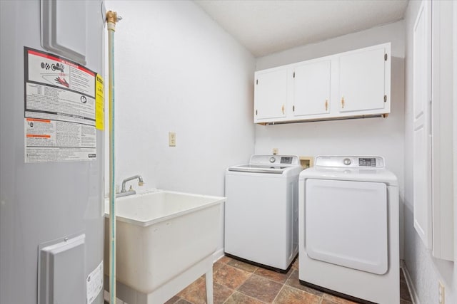 laundry area with electric water heater, independent washer and dryer, cabinets, and sink