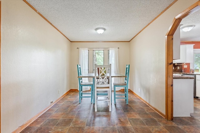 dining space with a textured ceiling and ornamental molding