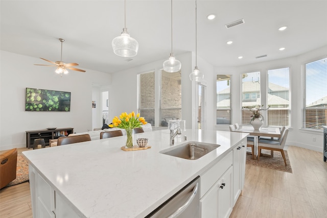 kitchen with a center island with sink, light hardwood / wood-style flooring, sink, white cabinetry, and ceiling fan