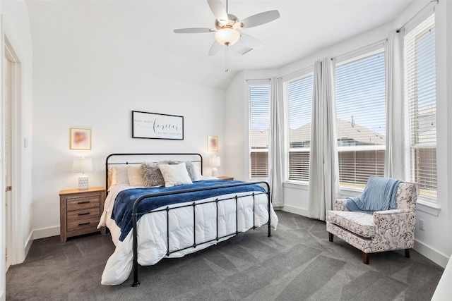 bedroom with ceiling fan, vaulted ceiling, and dark colored carpet