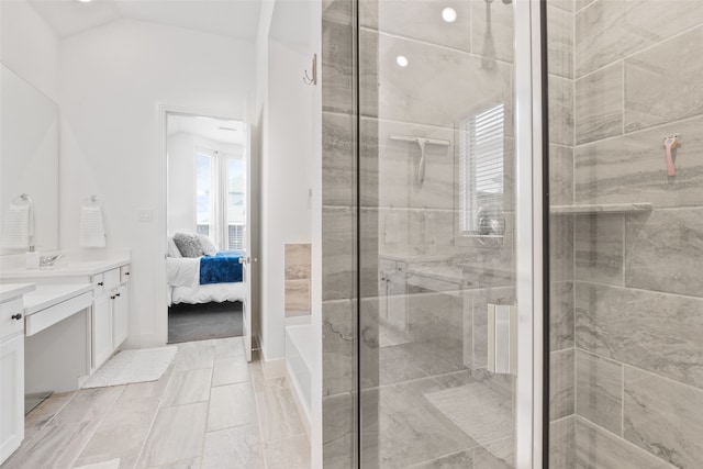 bathroom featuring lofted ceiling, a shower with shower door, and vanity