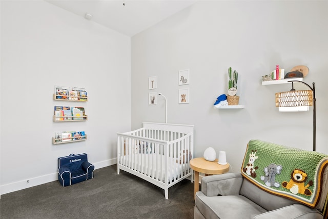 bedroom with a nursery area and dark carpet