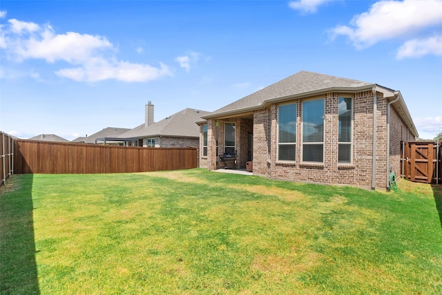 rear view of house featuring a lawn and a patio area