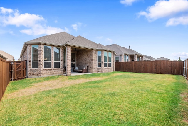 back of property with a patio area and a yard