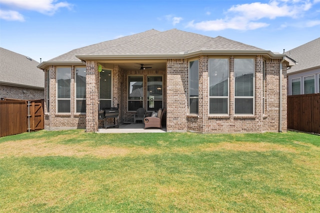 rear view of property with a yard, ceiling fan, and a patio