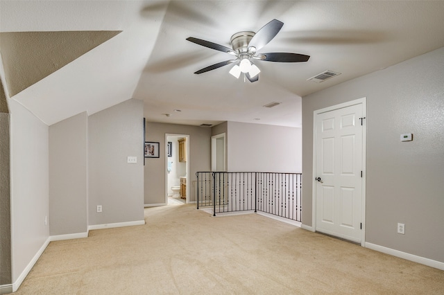 carpeted empty room featuring vaulted ceiling and ceiling fan