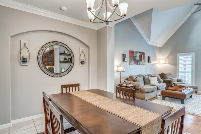 dining area with light hardwood / wood-style flooring, an inviting chandelier, and ornamental molding