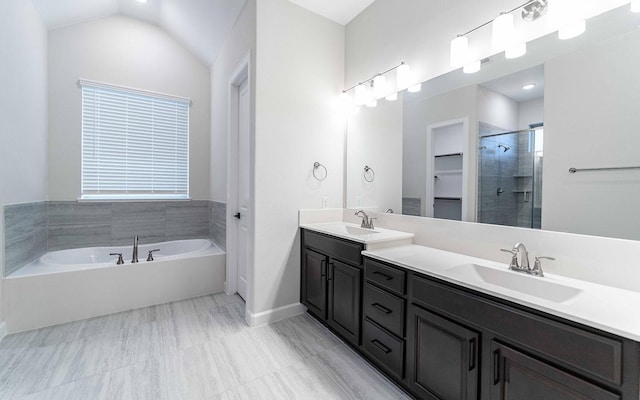 bathroom with separate shower and tub, vanity, and vaulted ceiling