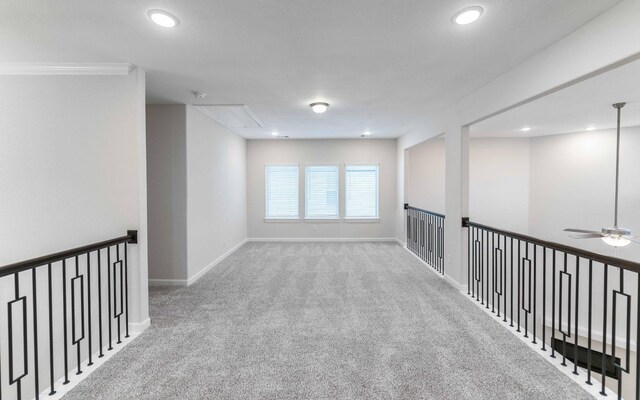 spare room with light colored carpet, ceiling fan, and crown molding