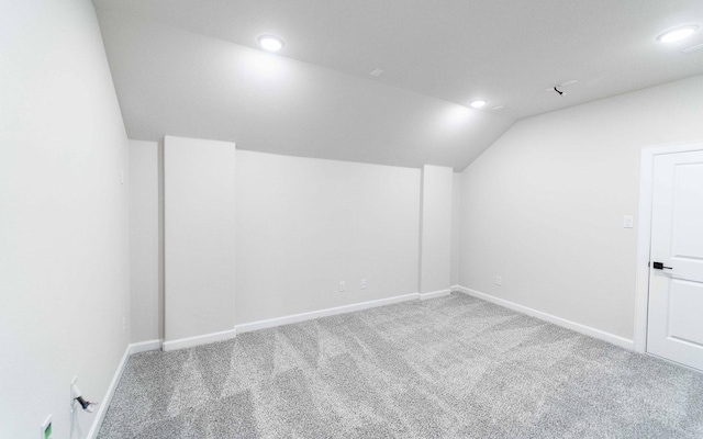 additional living space featuring lofted ceiling and carpet floors