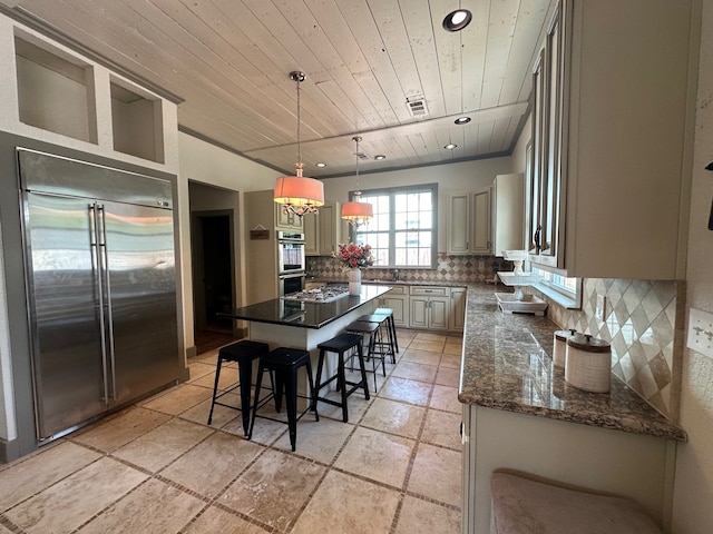 kitchen with wood ceiling, a center island, decorative backsplash, a kitchen breakfast bar, and appliances with stainless steel finishes