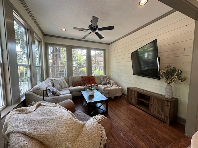 living room featuring dark wood-type flooring, ceiling fan, a healthy amount of sunlight, and a textured ceiling