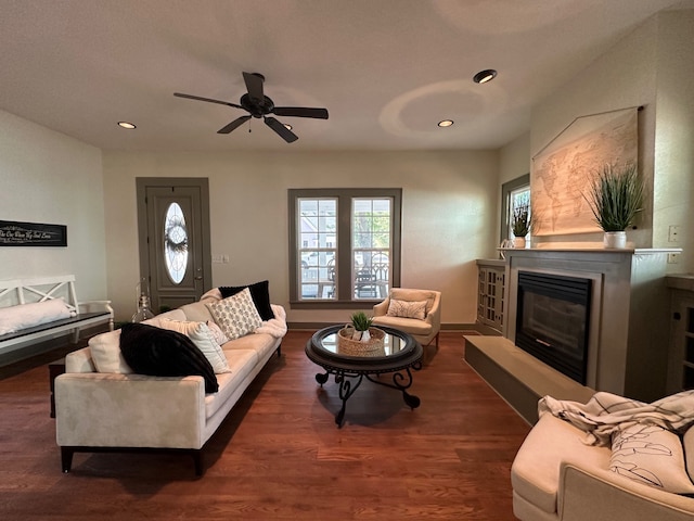 living room with ceiling fan and dark wood-type flooring