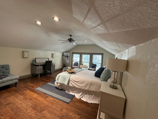 bedroom with a textured ceiling, vaulted ceiling, ceiling fan, and dark wood-type flooring