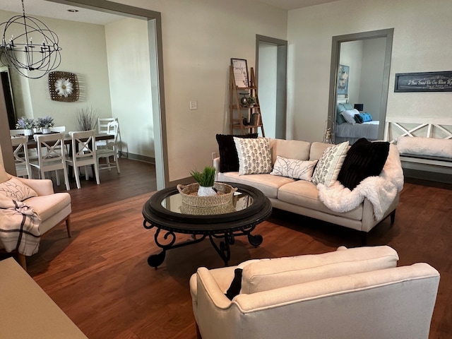 living room featuring an inviting chandelier and dark hardwood / wood-style flooring