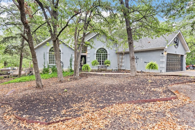 view of front of house with driveway, a shingled roof, and a garage