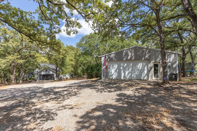 detached garage featuring dirt driveway