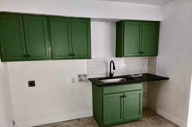 kitchen with tasteful backsplash, green cabinetry, and sink